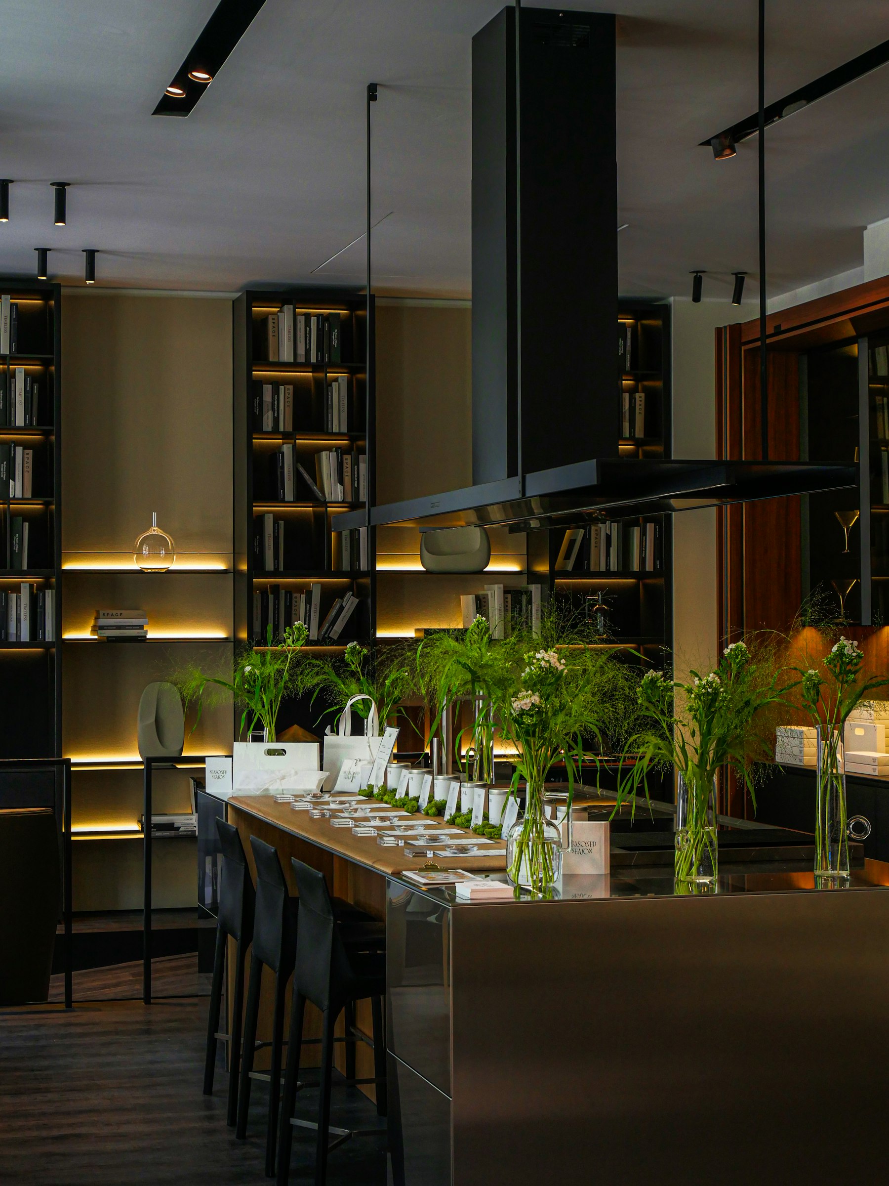 Island with stools and built-in bookshelves in a Montclair house